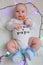 Happy baby with a lollipop on a white background with lights.