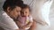 Happy Baby Loves Daddy Kisses. Loving Father kissing cute little adorable kid on bed. Close-up portrait. Indian ethnicity. Side