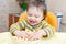 Happy baby playing with corn curls