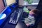 Happy baby is sitting at the computer keyboard with a bottle of milk in