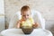 Happy baby sitting in highchair and eating greek yogurt