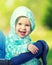 Happy baby smiling in a blue hood in the stroller for a walk in