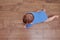 Happy baby toddler crawls on a wooden laminate. Funny child on the parquet in the home living room, aged 6-11 months