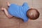 Happy baby toddler crawls on a wooden laminate. Funny child on the parquet in the home living room, aged 6-11 months