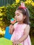 Happy baby toddler girl smelling and savoring a large colorful lollipop smell, scent or aroma