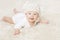Happy Baby in White Knitted Hat Crawling on White Blanket