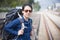 Happy backpacker asian woman in casual dress and bag on,wait for the railway train at station