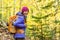 Happy backpacker girl hiking in autumn forest. Young asian hiker woman in outdoor gear for cold weather with backpack looking at