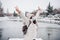 Happy backpacker woman wearing face mask standing on pier in front of frozen lake in city. travel and Lifestyle during winter in