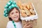 Happy baker boy holding basket with fresh bakery products