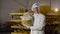 Happy baker showing a large round loaf of bread with image of smile at camera