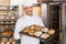 Happy baker showing tray of fresh bread