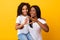 Happy balck mom and girl showing heart symbol with fingers