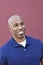 Happy bald African American man looking away over colored background