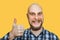 Happy bald smiling guy with a beard showing thumbs up on an isolated background