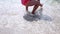 Happy barefoot child have fun on beach walk. Girl run along sea surf by water pool and jump with splashes. Summer