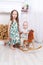 Happy barefoot girl and her little brother on rocking horse