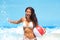 Happy beach Asian bikini woman having fun running in waves playing with beach ball on summer travel vacation. Holidays