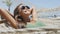 Happy beach vacation woman putting on sunglasses relaxing lying down in hammock