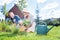 Happy beaming couple sitting hear garden sprinkler while planting flowers