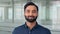 Happy bearded Indian business man leader standing in office, headshot portrait.