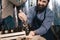 Happy bearded man in apron pours barley into hand of craft brewery. Process of beer manufacturing.