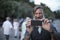 Happy, bearded man in Athens is taking a foto with the smart phone