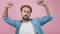 Happy bearded man dancing in studio with pink background