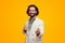 Happy bearded man gesturing money or salary on yellow backdrop