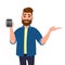Happy bearded man showing or holding digital calculator device in hand and pointing, presenting something to copy space.