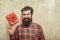 Happy bearded man smiling with red gift box with bow