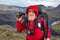 happy bearded man traveler with hiking equipment on mountain landscape background. nature hikes in the mountains