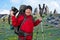 Happy bearded tourist with camera, Navigator and trekking poles on the background of beautiful mountains