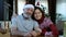 Happy beared senior man in red christmas hat with adult daughter, celebrating new year
