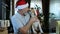 Happy beared senior man in red christmas hat with his dog beagle leaking him