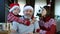 Happy beared senior man in red christmas hat with his grandson and adult daughter, celebrating new year