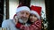 Happy beared senior man in red christmas hat with his grandson, celebrating new year