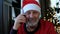 Happy beared senior man in red christmas hat talking on the smart phone
