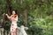 Happy beautiful Asian Chinese woman artist in traditional chi-pao cheongsam in a garden play musical instruments violin on bridge