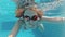 Happy beautiful attractive young woman in the swimming pool, underwater view. Action camera