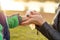 Happy and beautiful blonde woman in hat playing wipes hands with napkins of baby son in a warm jacket in the autumn park