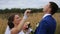 Happy beautiful bride and groom on field