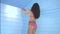 Happy beautiful brunette woman smiling and dancing on bed over blue wooden wall background - video in slow motion. Healthy life an