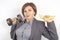 Happy beautiful business woman in a suit lifts a dumbbell and a banana in her hands