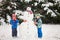 Happy beautiful children, brothers, building snowman in garden