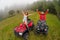 Happy beautiful couple sitting on four-wheelers ATV