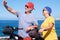 Happy beautiful elderly couple standing on the cliff taking a selfie with smartphone. Active retirees enjoying healthy lifestyle