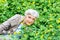 Happy beautiful elderly woman sitting on a glade