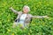 Happy beautiful elderly woman sitting on a glade of yellow flowers in spring