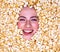 Happy beautiful female face in popcorn